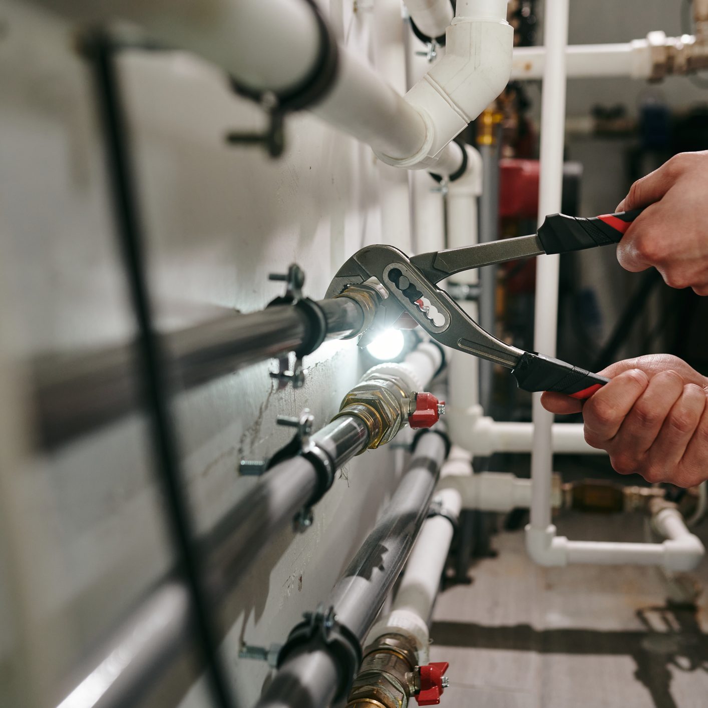 Hands of technician or plumber repairing broken pipes in toilet